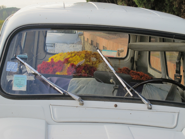 a '4 L' with flowers inside, outside a cemetery